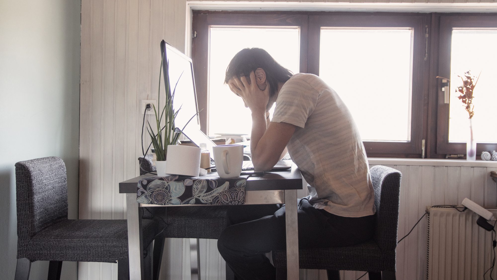 Worried man behind computer working from home