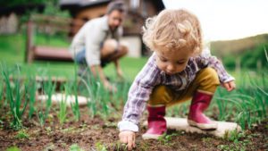 A small girl with unrecognizable father outdoors gardening | Massachusetts Association of Buyer Agents | homebuyer real estate buyers broker