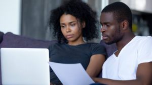 Serious african couple pay bills online on laptop at home | Massachusetts Association of Buyer Agents | homebuyer real estate buyers broker