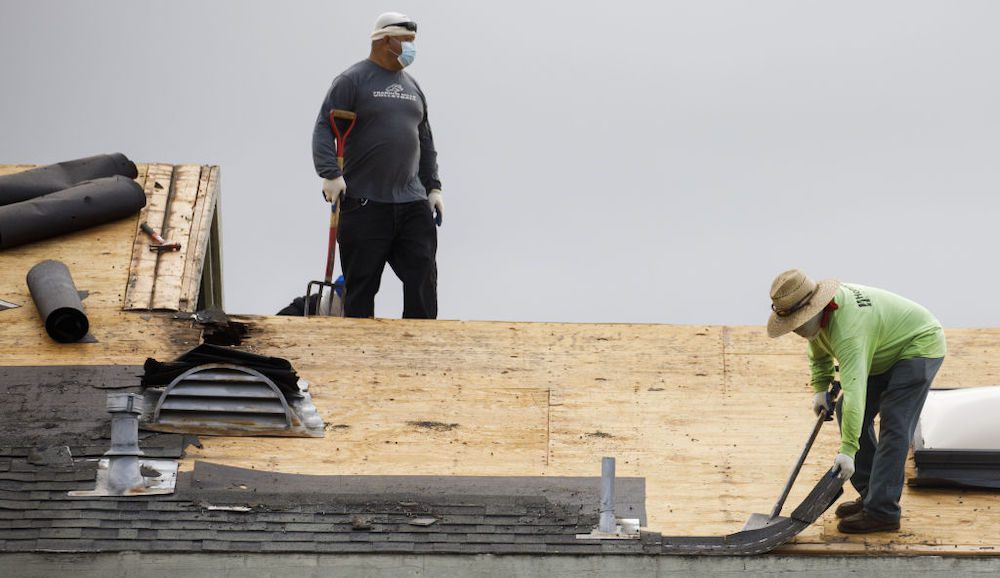 construction workers on roof of home